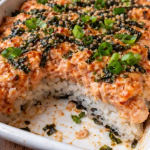 Easy Spicy Salmon Sushi Bake prepared in a baking dish with fresh ingredients.
