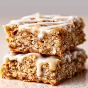 Delicious Cinnamon Roll Oatmeal Bars topped with icing on a wooden table