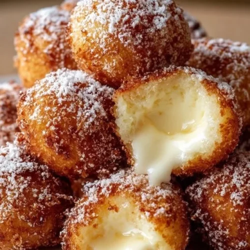 Delicious crispy fried cheesecake bites served on a plate.