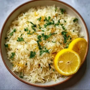 Bowl of Greek Lemon Rice garnished with fresh herbs and lemon wedges