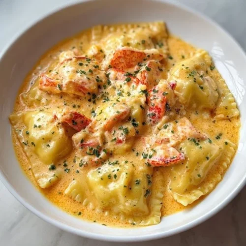 Plate of lobster ravioli with creamy lemon sauce garnished with herbs