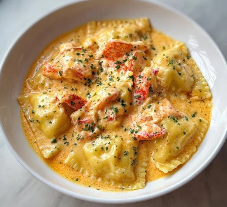 Plate of lobster ravioli with creamy lemon sauce garnished with herbs