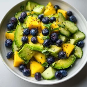 Mango Cucumber Salad topped with blueberries and avocado on a plate
