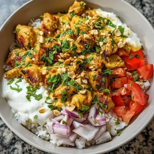 Plate of peanut chicken served with vegetables and rice