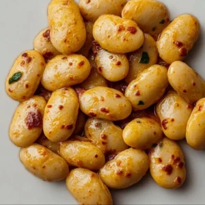 Plate of Tuscan Marry Me Butter Beans garnished with herbs and spices