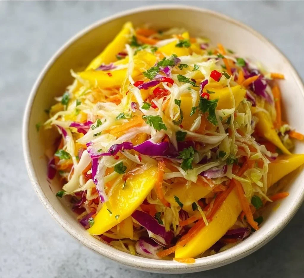 Colorful Mango Slaw with shredded vegetables and mango slices on a plate